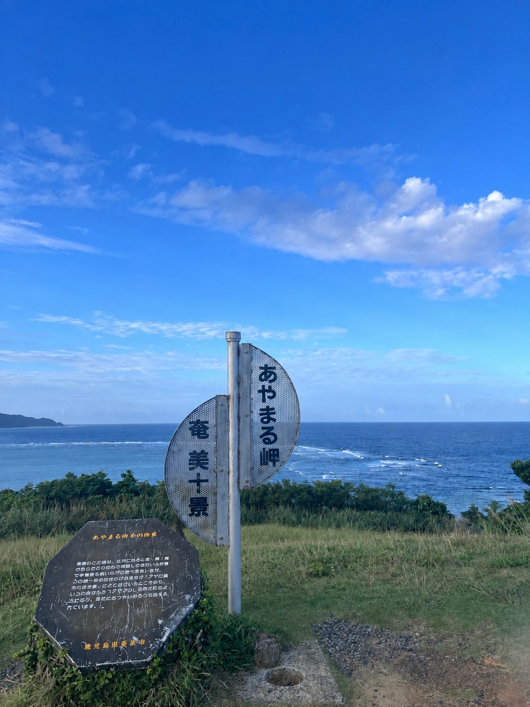 あやまる岬の入口に立つ看板と、その先に広がる太平洋の景色