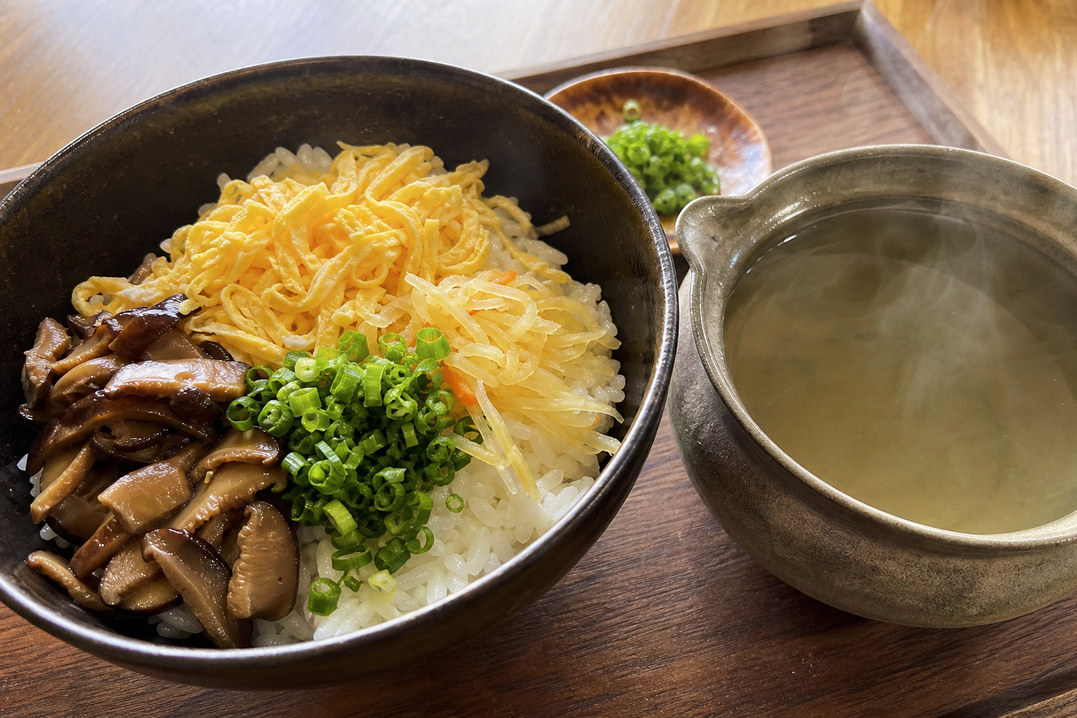鶏飯の具材が盛られた茶碗と、湯気の立つ鶏スープの土瓶